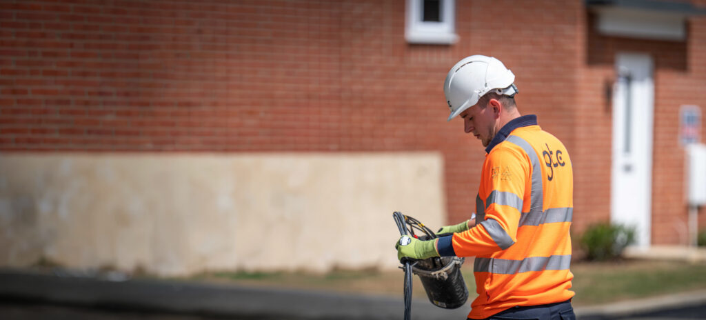 A GTC fibre network engineer works on site for a housebuilder fitting cables