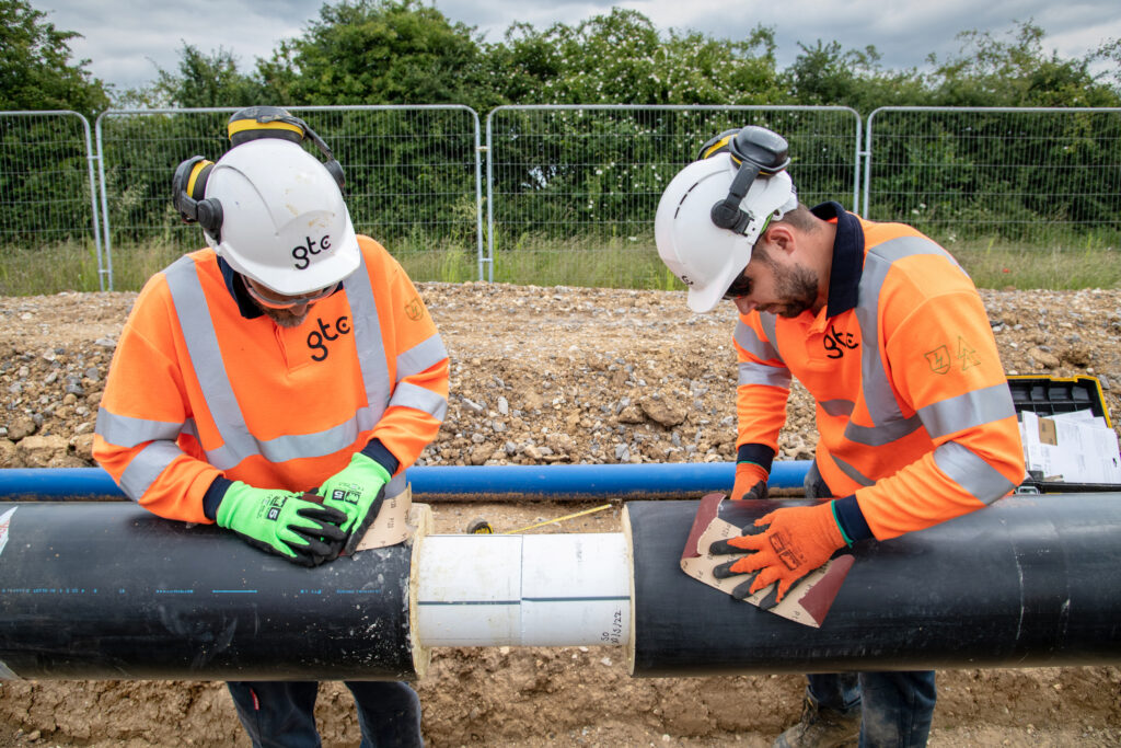 Two GTC engineers work on a heat network pipe installation