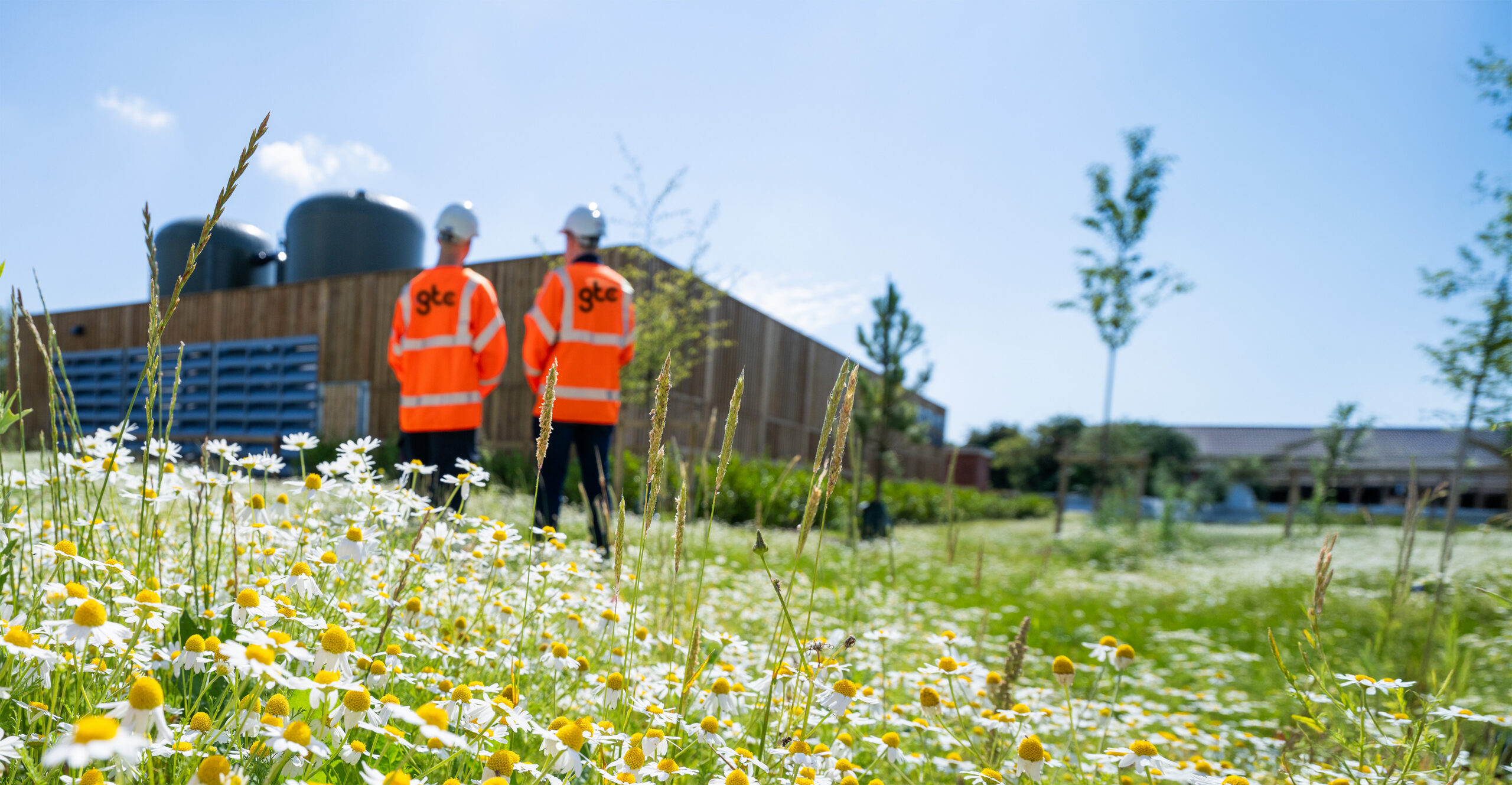 Two GTC workers in front of a community heat hub build for a new homes developer